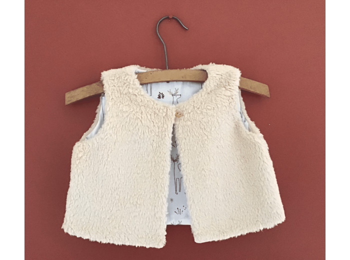 Gilet berger réversible en fausse fourrure et tissu coton petits cerfs sur fond blanc .