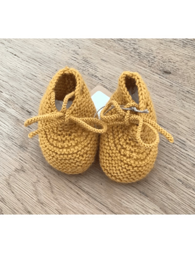 Chaussons bébé , en laine coloris moutarde, avec des petits noeuds.